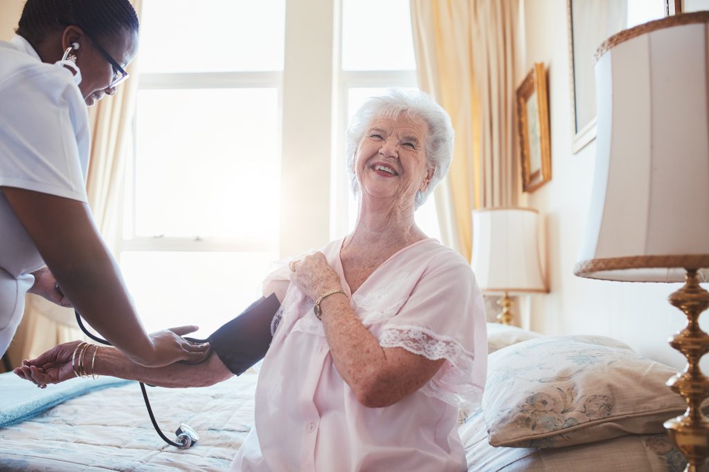 Nurse checking blood pressure of a senior woman Nurse checking blood pressure of a senior woman